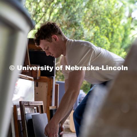 Alex Buescher of Phi Kappa Theta organizes a stack of picture frames during the Big Event.  May 4, 2024. Photo by Kirk Rangel for University Communication.